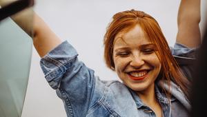 Junge Frau mit roten Haaren, die strahlt. 